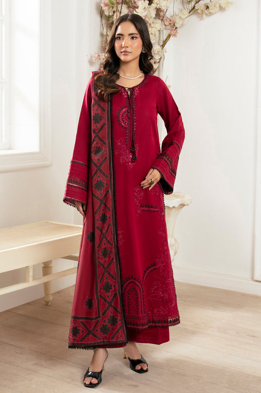 Woman wearing a red embroidered outfit with a matching dupatta in a well-lit room.