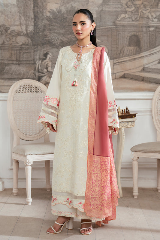 Woman in a traditional outfit with pink and white design in an elegant room.