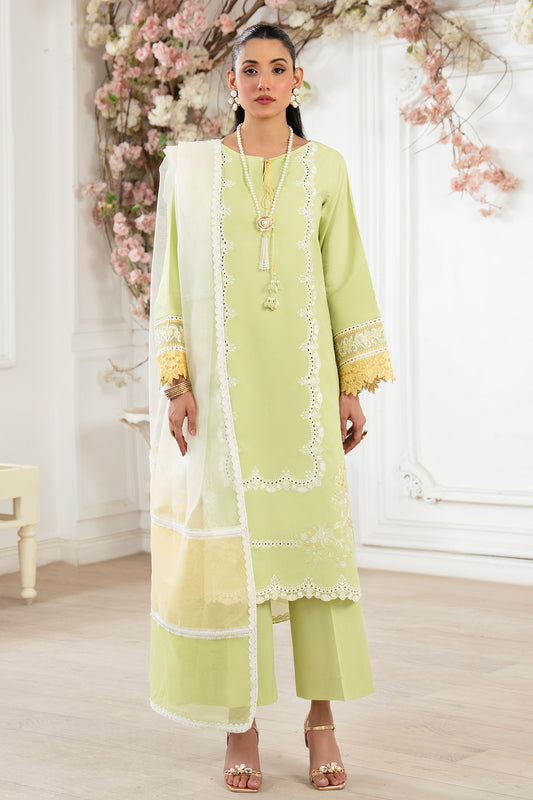 Woman wearing a light green traditional outfit with a white dupatta in a decorated room.