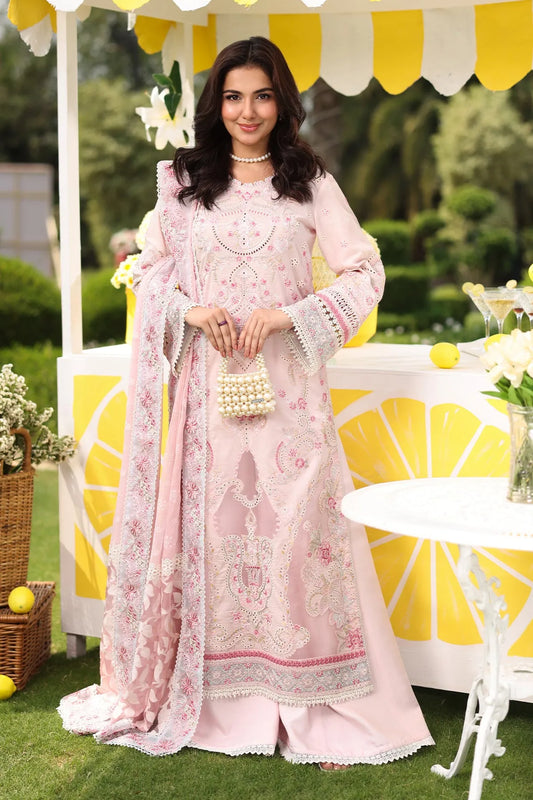 A woman modeling a powder pink 3-piece embroidered festive outfit, consisting of a shirt with sleeves, an organza border, and a dupatta, with a dyed cotton trouser. The outfit features floral and geometric patterns.